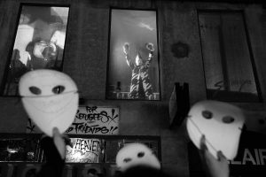 ORLAN performs with hands raised in the window of 210 Rue Saint Denis
